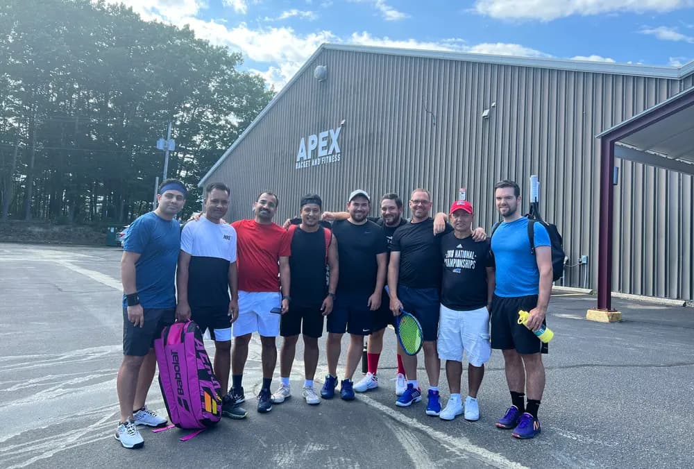 A group of men pose together outside Apex Racket and Fitness after playing.